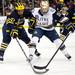 Michigan junior defenseman Mac Bennett competes for possession of the puck with Notre Dame Center T.J. Tynan on Sunday, March 24. Daniel Brenner I AnnArbor.com